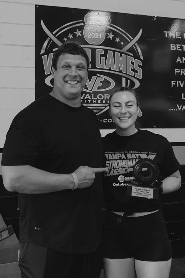 NIck standing with Shannon as she holds her award in the shape of a tire at the Valor Games
