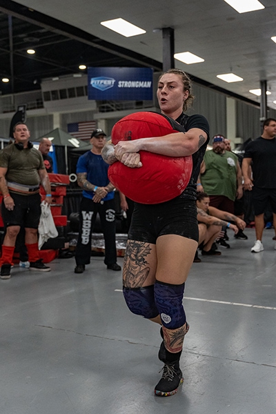 Shannon Palmer carrying a sandbag in competition